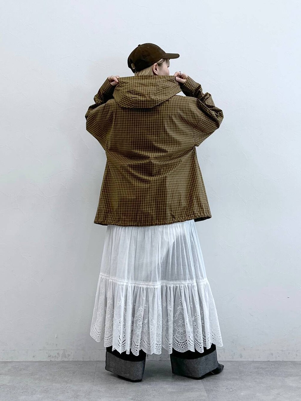 ブラック系のデニムパンツ、イエロー系のシャツ/ブラウス、ホワイト系のスカートを着用したレディースの夏コーディネートの5枚目の写真