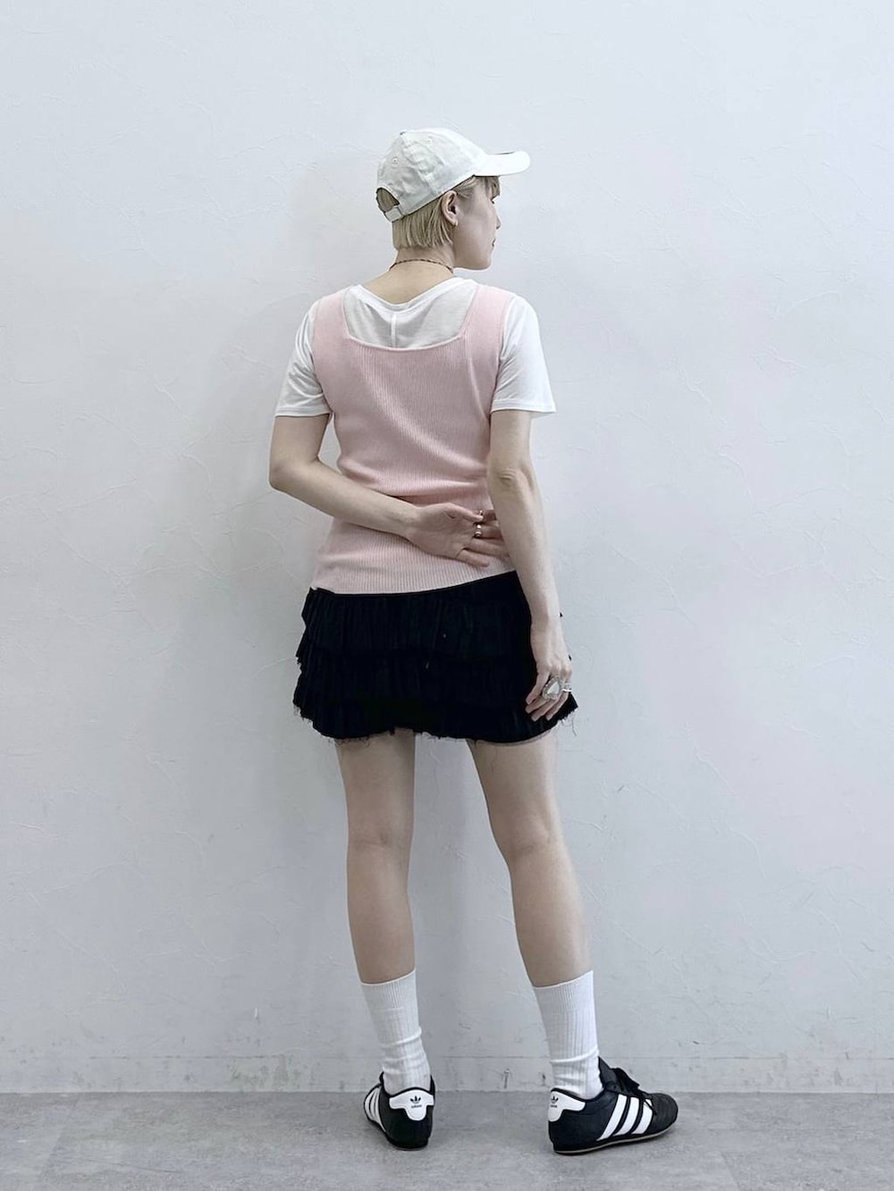 ブラック系のスニーカー、ピンク系のタンクトップ、ホワイト系のTシャツ/カットソーを着用したレディースの春コーディネートの6枚目の写真