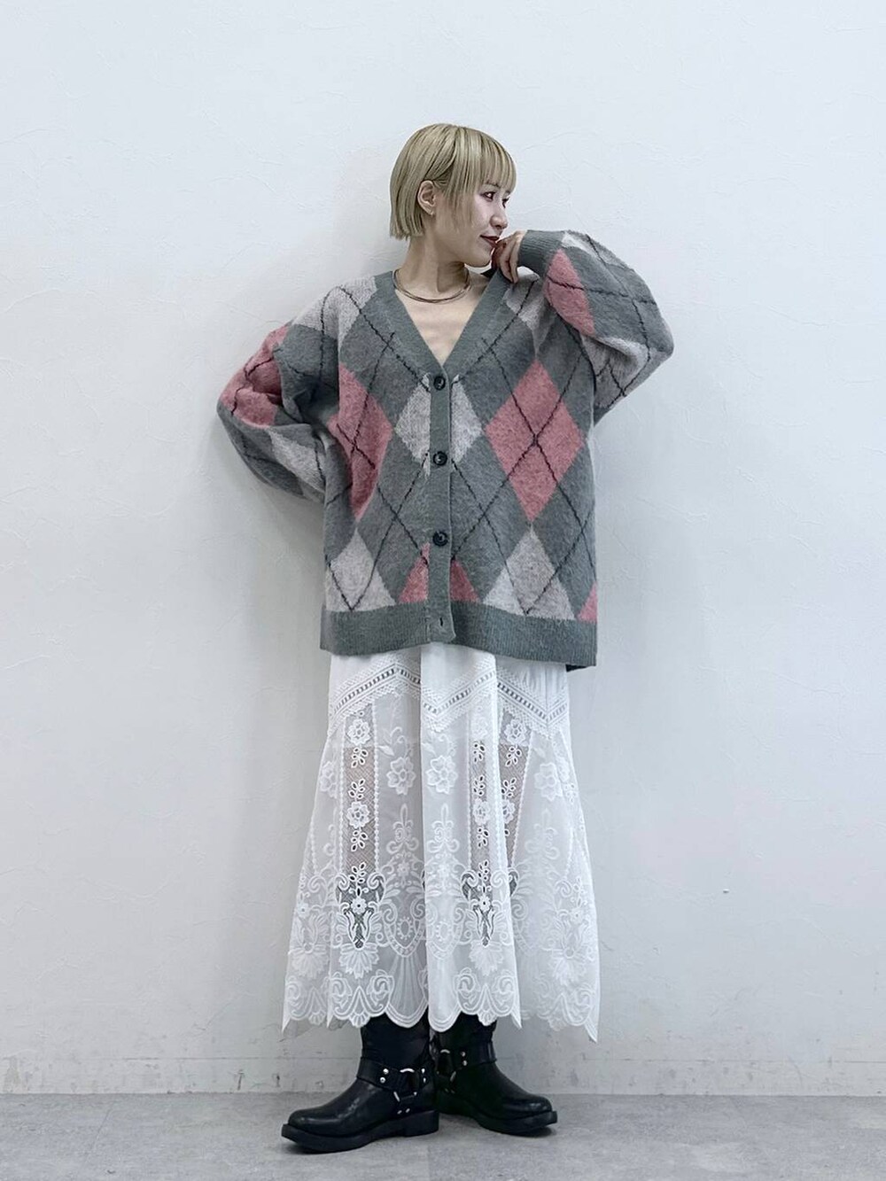 ブラック系のブーツ、グレー系のカーディガン/ボレロ、ホワイト系のスカートを着用したレディースの秋コーディネートの3枚目の写真