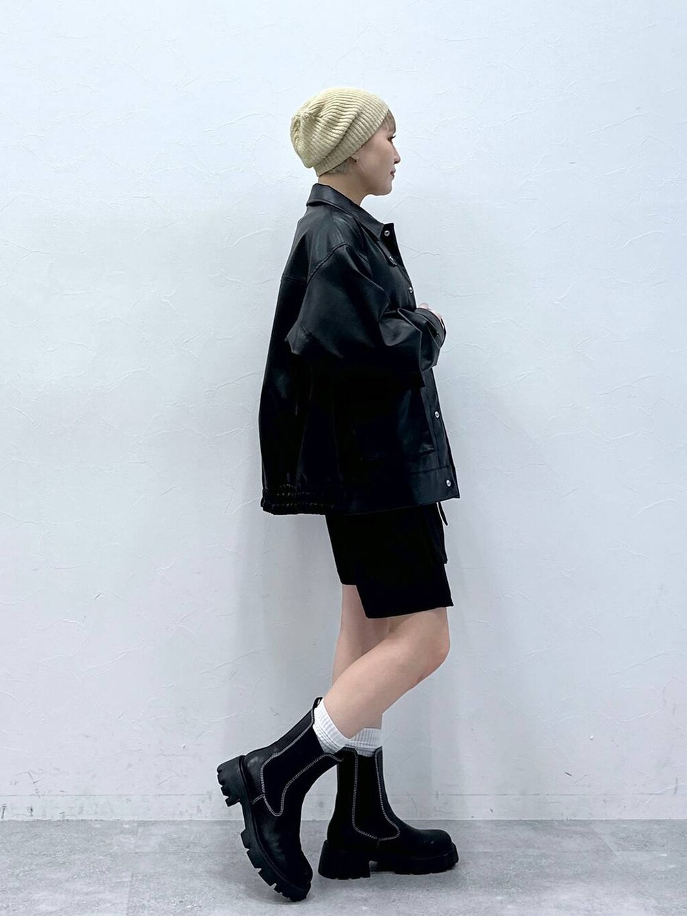 ブラック系のブーツ、ホワイト系のTシャツ/カットソー、ブラック系のスカートを着用したレディースの秋コーディネートの4枚目の写真