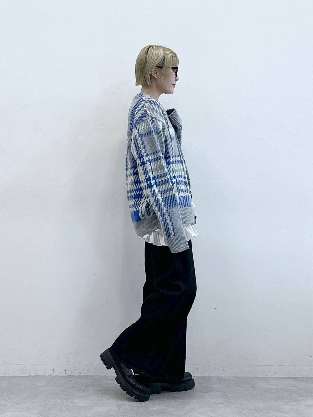 ブラック系のデニムパンツ、ブラック系のローファー、グレー系のニット/セーターを着用したレディースの秋コーディネートの4枚目の写真