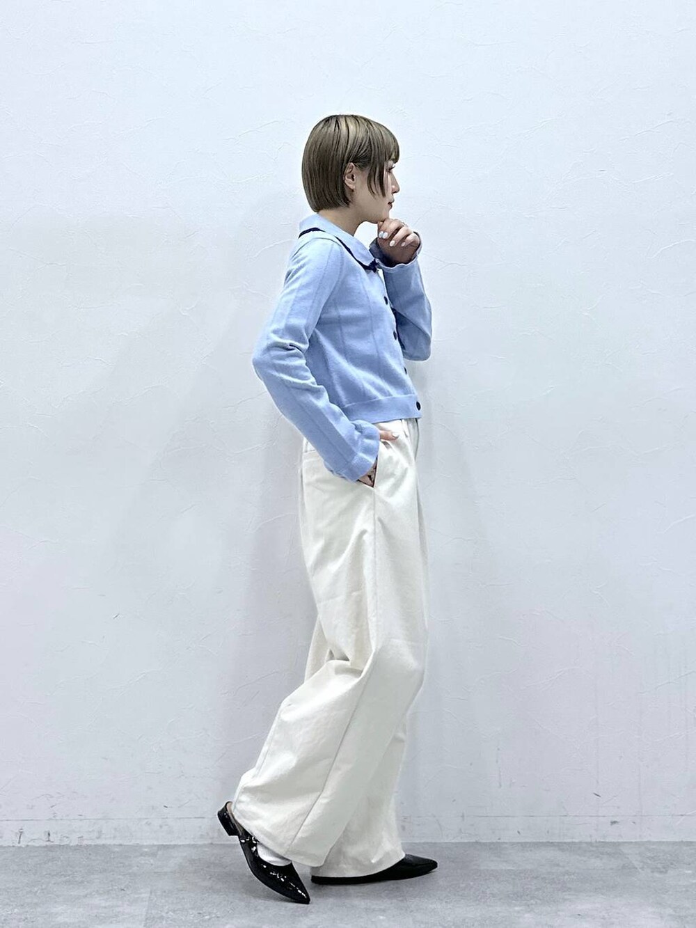 ホワイト系のチノパンツ、ブルー系のカーディガン/ボレロ、ブラック系のパンプスを着用したレディースの冬コーディネートの4枚目の写真