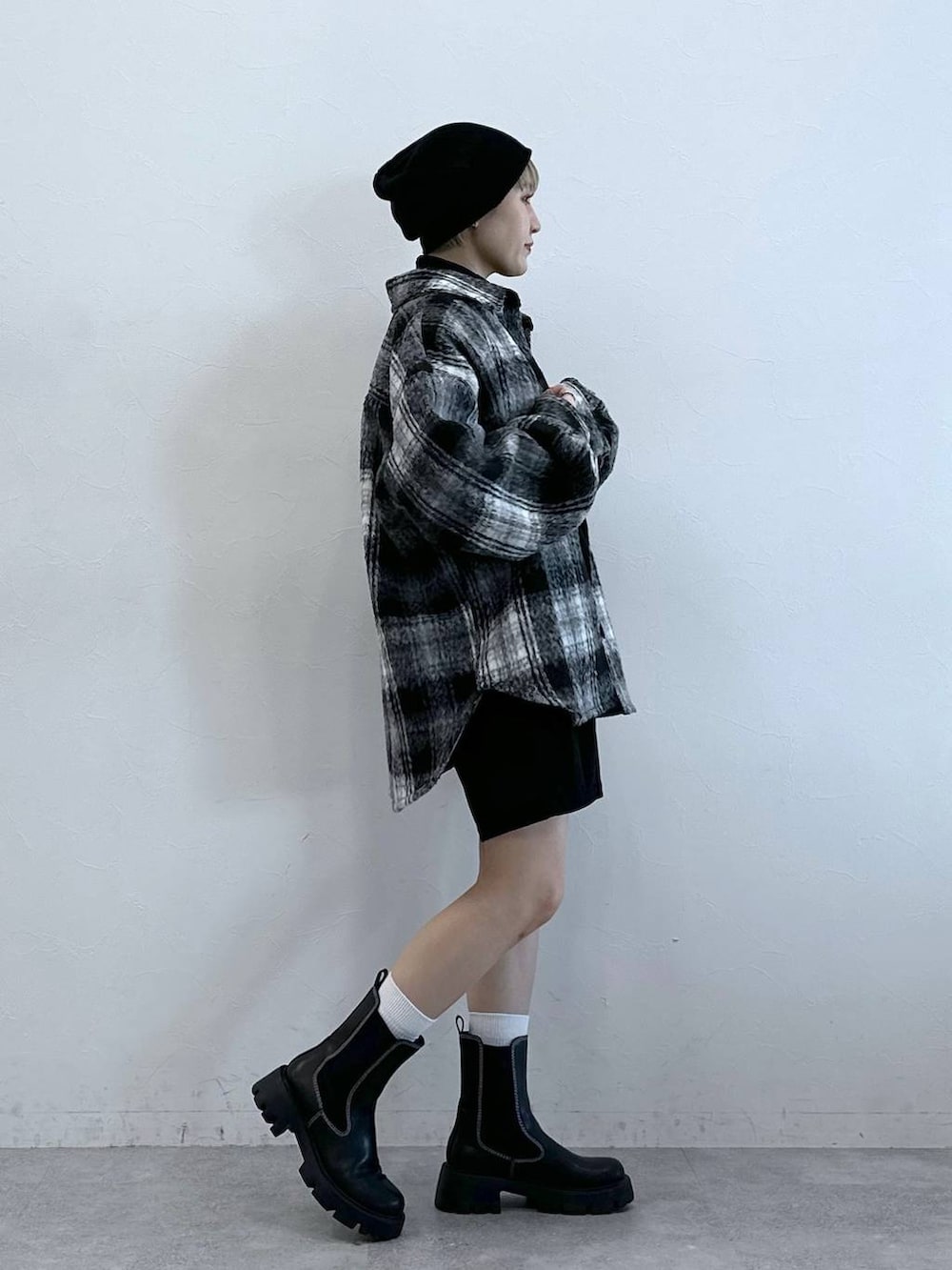 ブラック系のチノパンツ、ブラック系のブーツ、ブラック系のブルゾンを着用したレディースの冬コーディネートの4枚目の写真