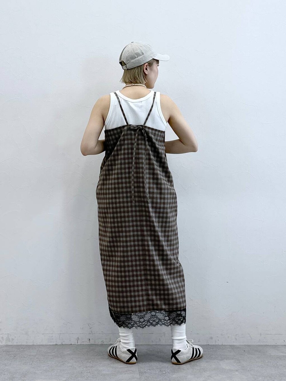 ホワイト系のスニーカー、グレー系のワンピースを着用したレディースの夏コーディネートの6枚目の写真