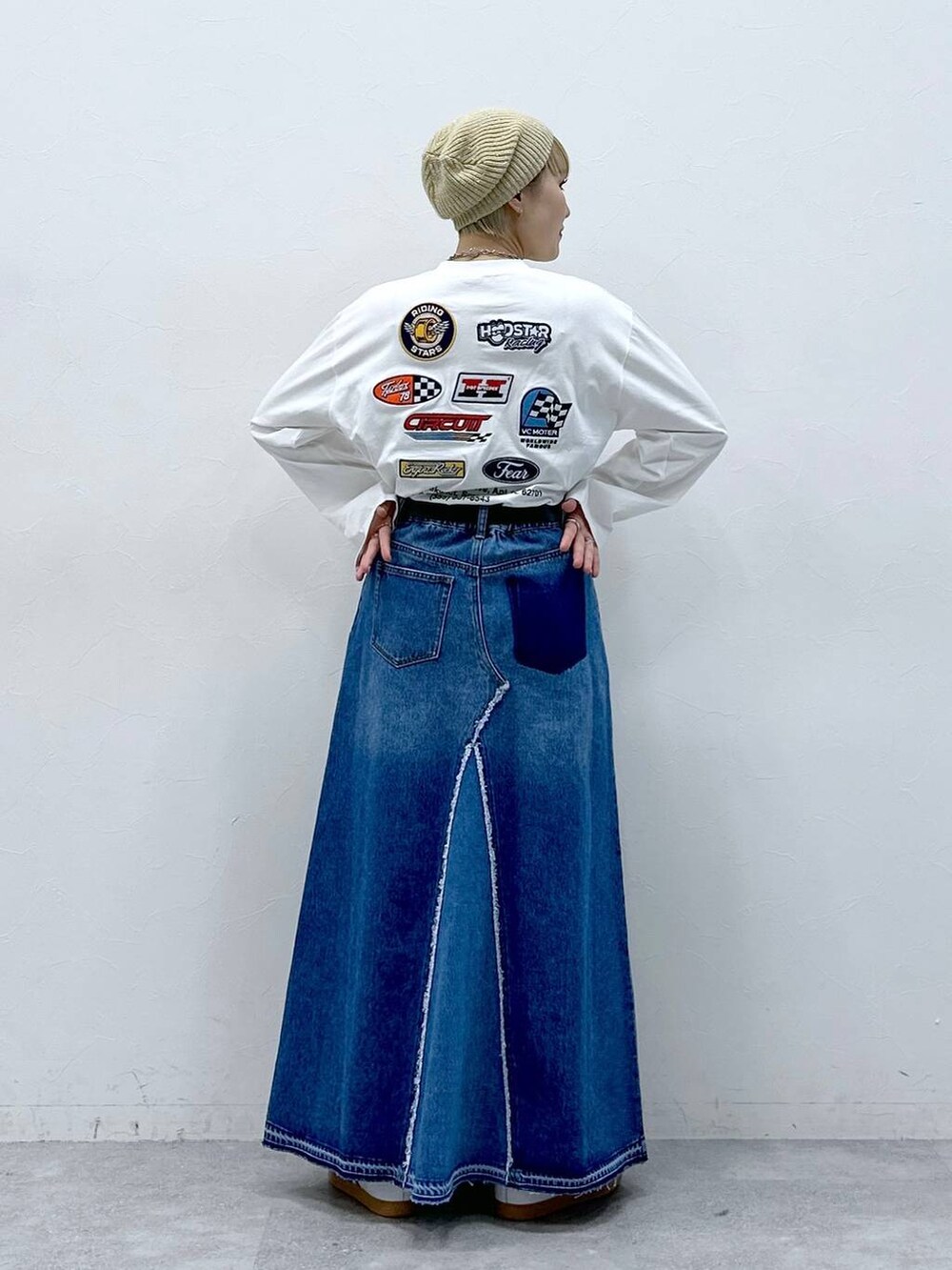 ブルー系のデニムスカート、ホワイト系のTシャツ/カットソー、ベージュ系のハンチング/ベレー帽を着用したレディースの冬コーディネートの4枚目の写真