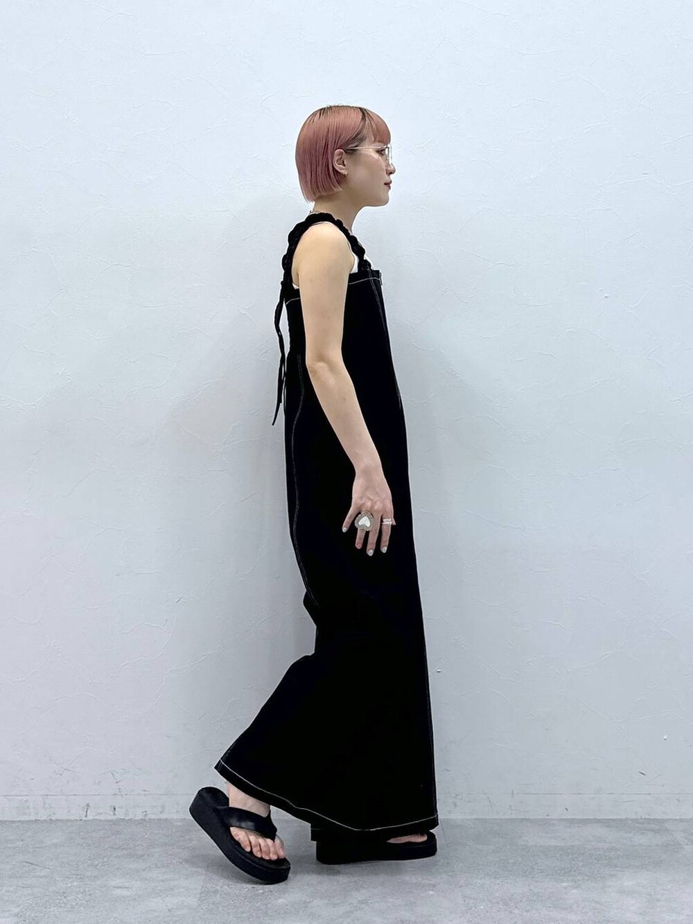 ホワイト系のタンクトップ、ブラック系のサロペット/オーバーオールを着用したレディースの春コーディネートの6枚目の写真