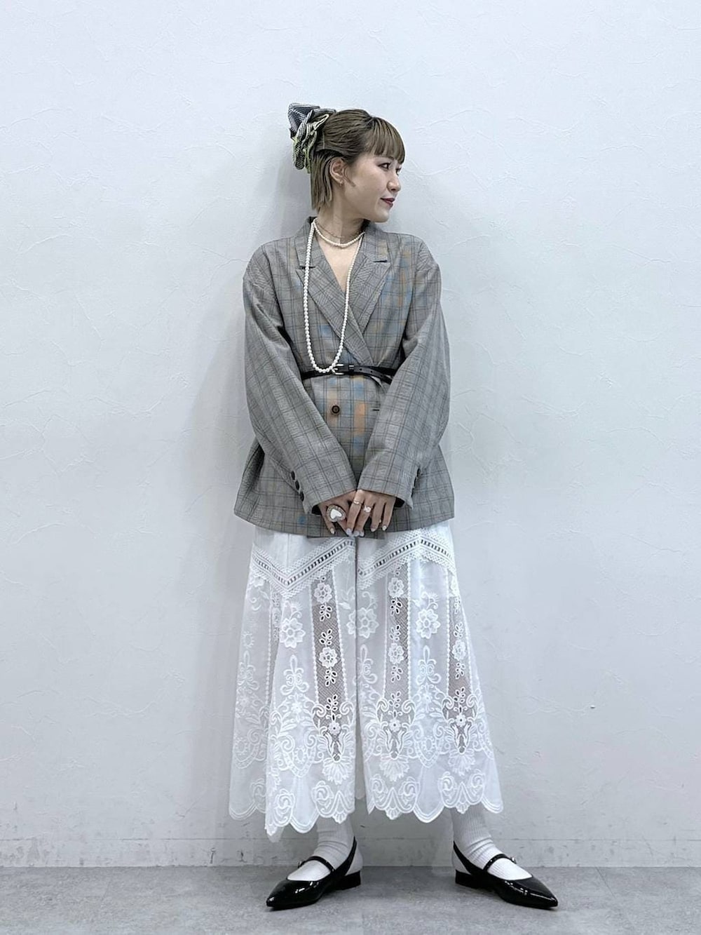 ホワイト系のスカート、ブラック系のパンプス、ベージュ系のテーラードジャケットを着用したレディースの冬コーディネートの3枚目の写真