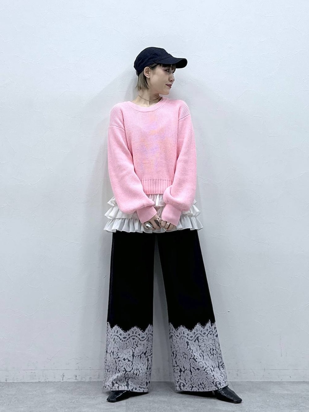 ホワイト系のキャミソール、ピンク系のニット/セーター、ブラック系のデニムパンツを着用したレディースの冬コーディネートの3枚目の写真