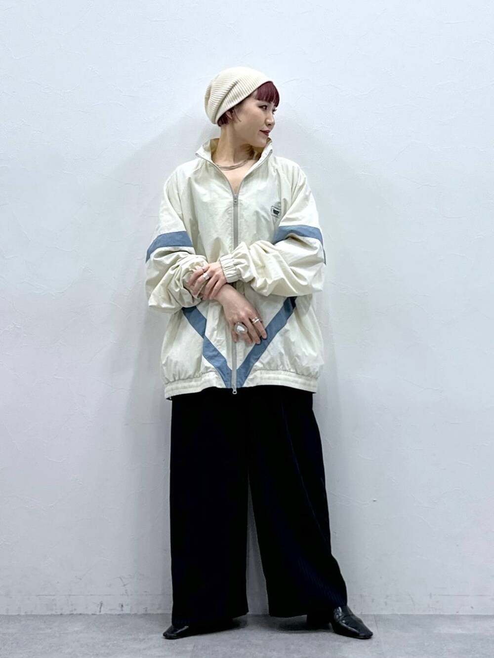 ホワイト系のブルゾン、ブラック系のスラックスを着用したレディースの春コーディネートの2枚目の写真