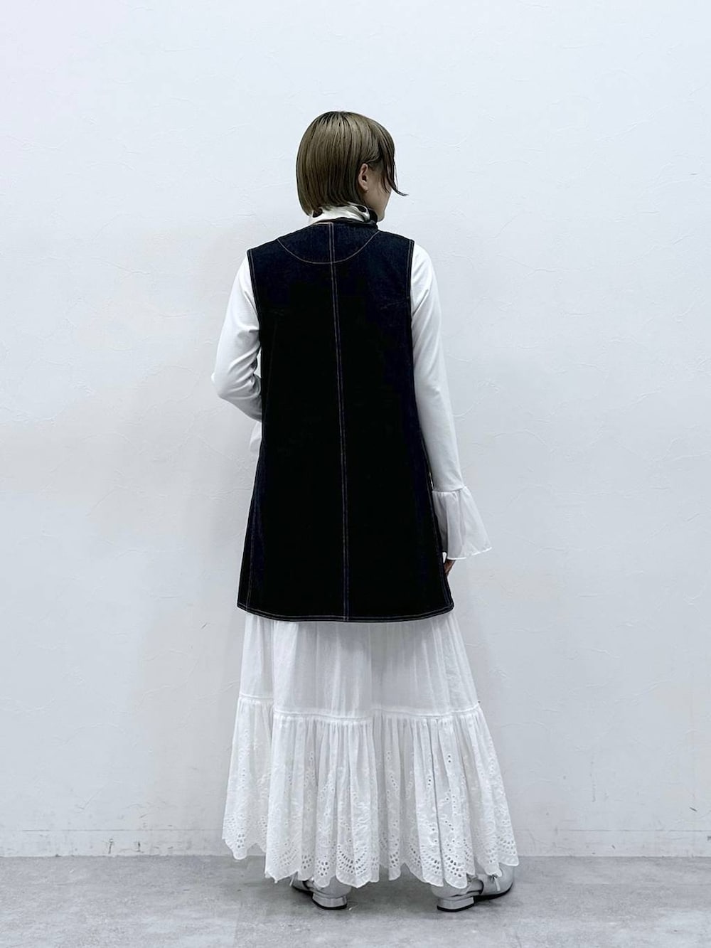 シルバー系のパンプス、ブラック系のワンピース、ホワイト系のTシャツ/カットソーを着用したレディースの冬コーディネートの7枚目の写真