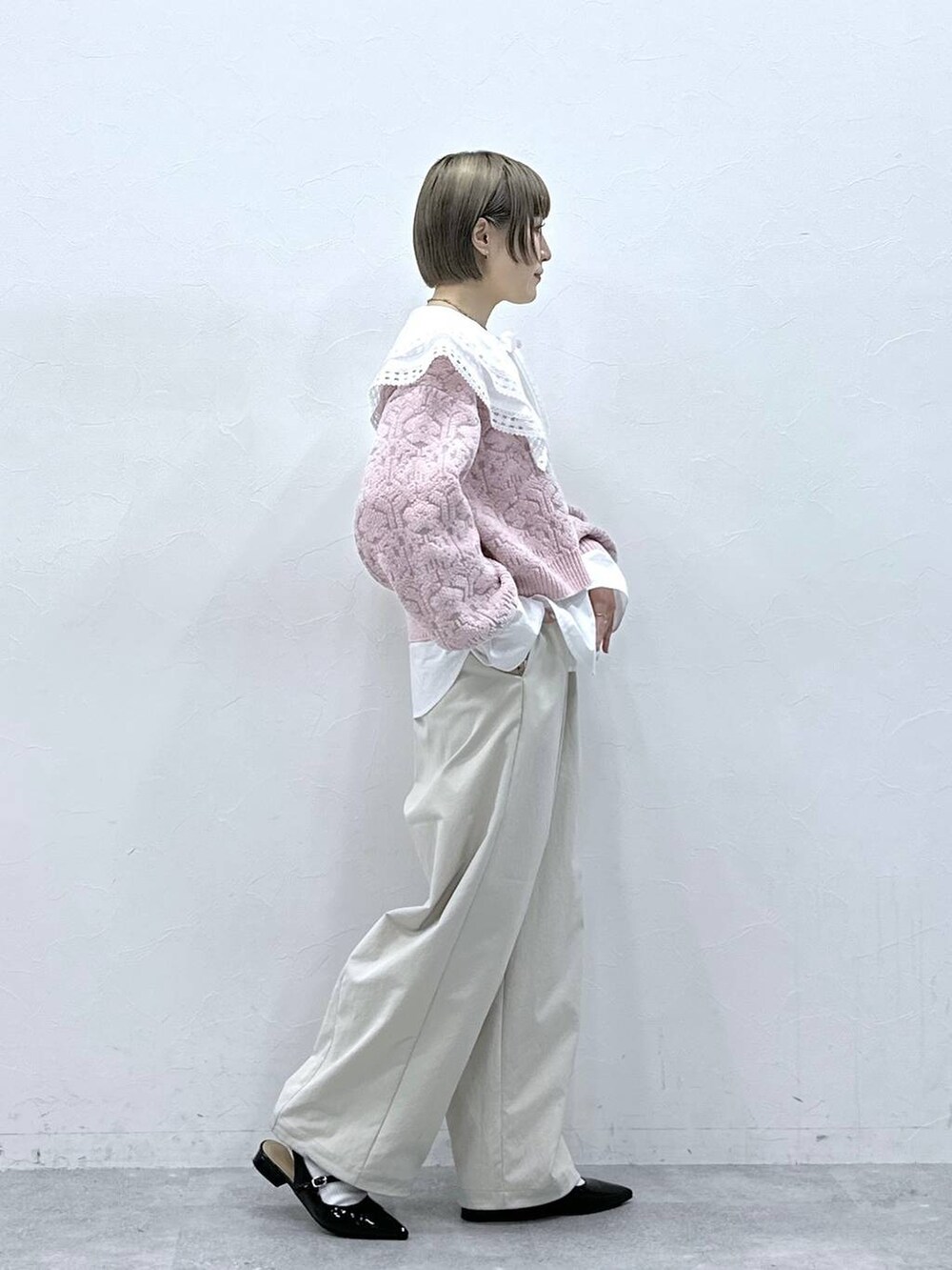ホワイト系のチノパンツ、ホワイト系のシャツ/ブラウス、ピンク系のニット/セーターを着用したレディースの冬コーディネートの5枚目の写真