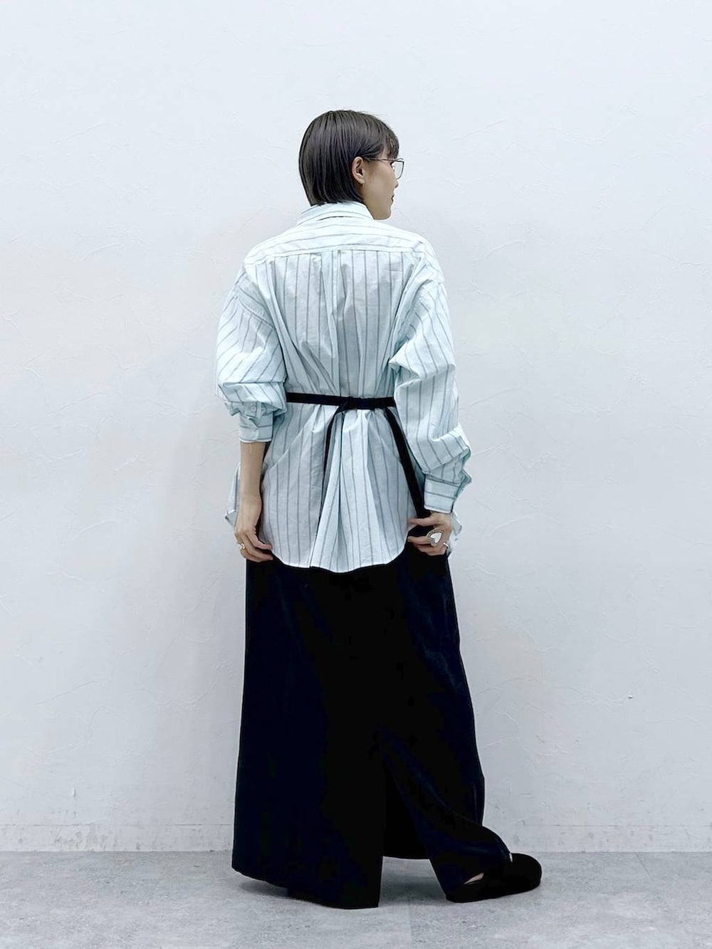 グリーン系のシャツ/ブラウス、ブラック系のボディバッグ/ウエストポーチ、ブラック系のモカシン/デッキシューズを着用したレディースの春コーディネートの5枚目の写真