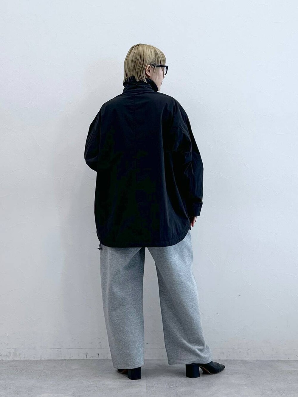 ブラック系のブルゾン、グレー系のスウェットパンツ、グレー系のメガネを着用したレディースの秋コーディネートの5枚目の写真