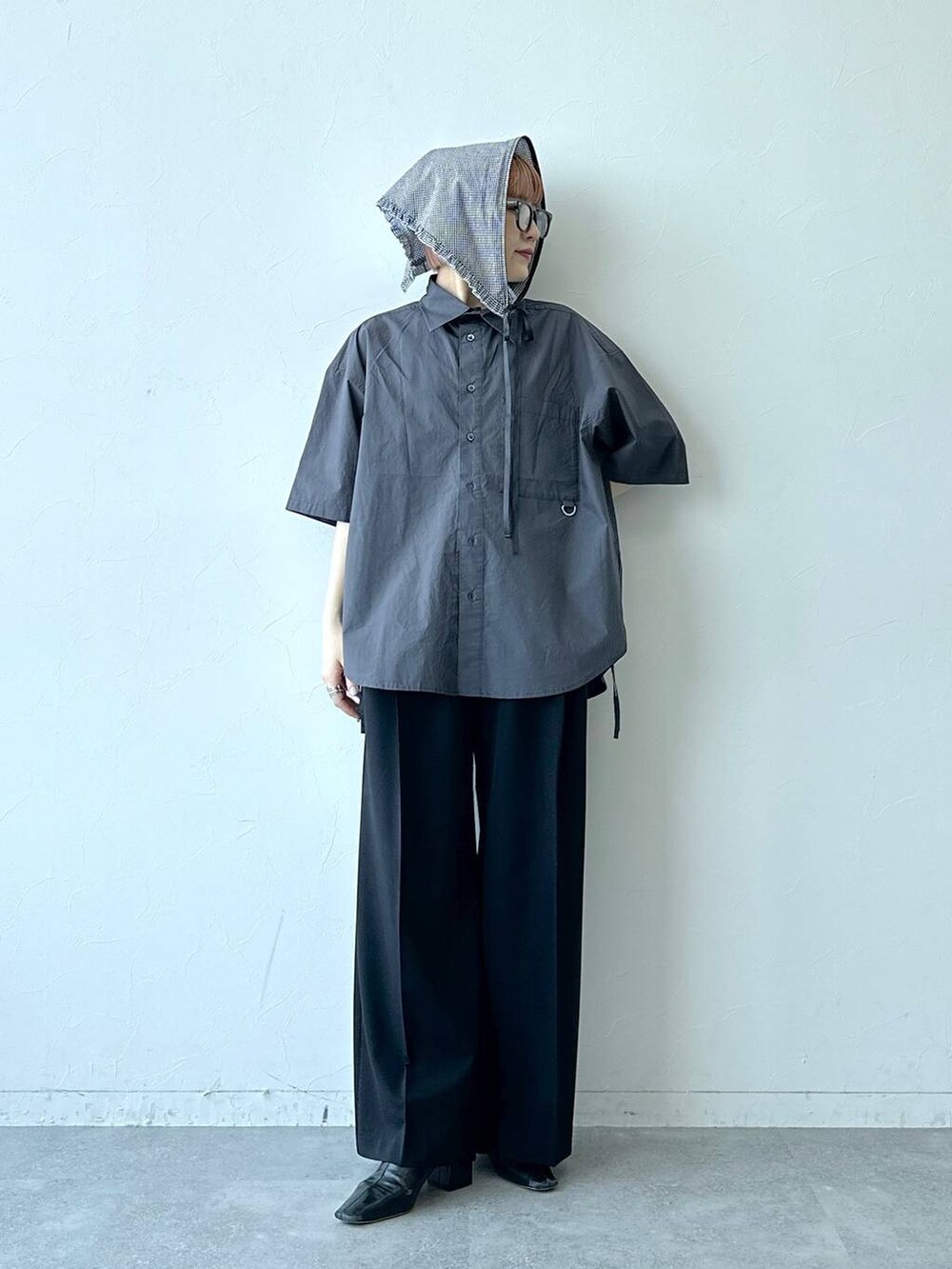 ブラック系のスラックス、グレー系のシャツ/ブラウス、グレー系のメガネを着用したレディースの夏コーディネートの2枚目の写真