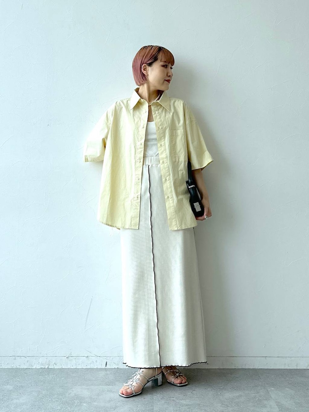 ホワイト系のスカート、イエロー系のシャツ/ブラウスを着用したレディースの春コーディネートの2枚目の写真