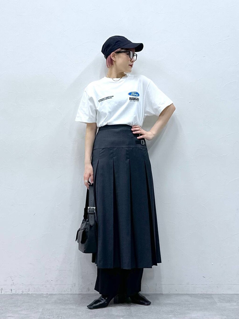 ブラック系のスラックス、グレー系のスカート、ホワイト系のTシャツ/カットソーを着用したレディースの春コーディネートの3枚目の写真