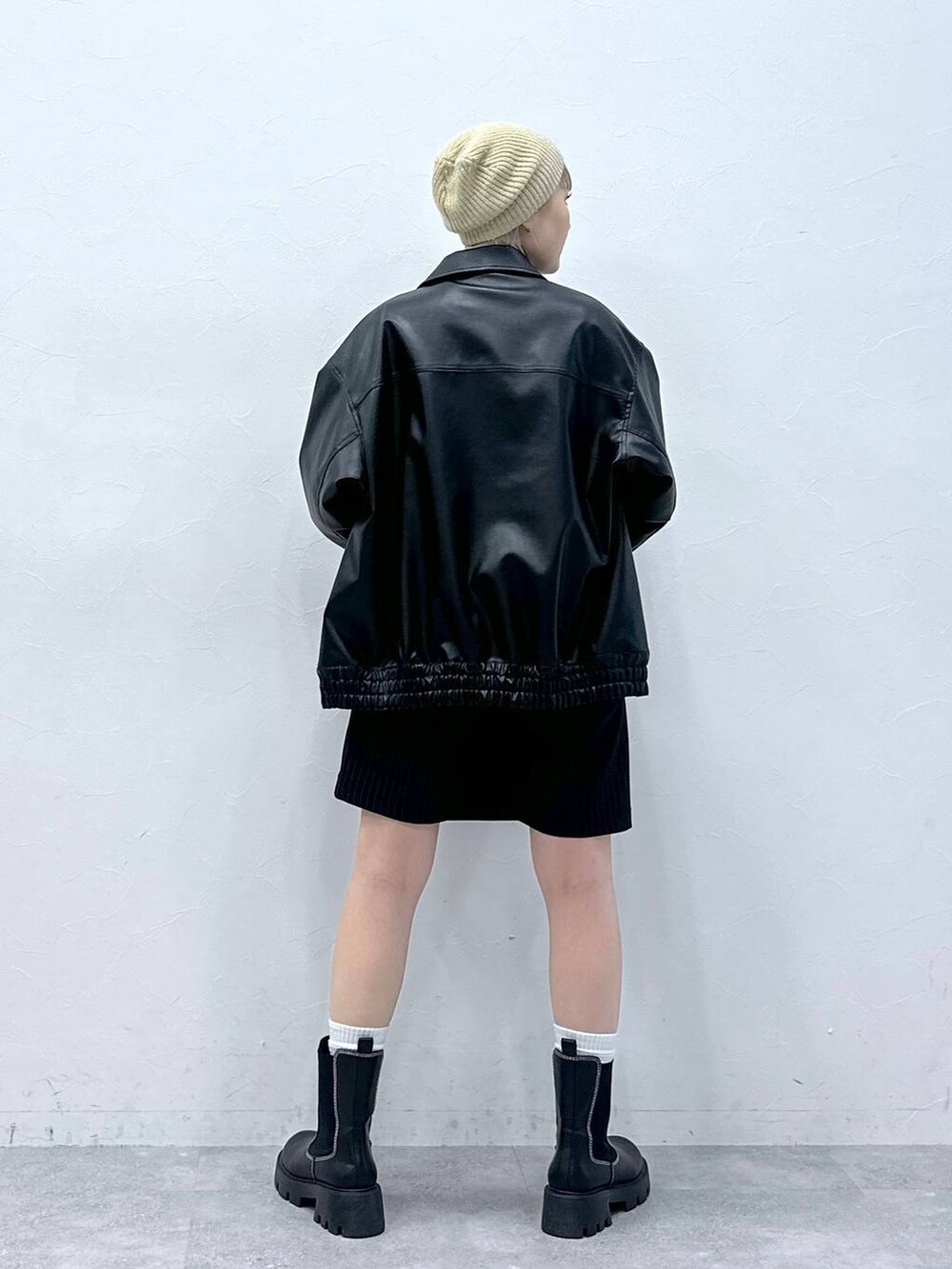 ブラック系のブーツ、ホワイト系のTシャツ/カットソー、ブラック系のスカートを着用したレディースの秋コーディネートの5枚目の写真