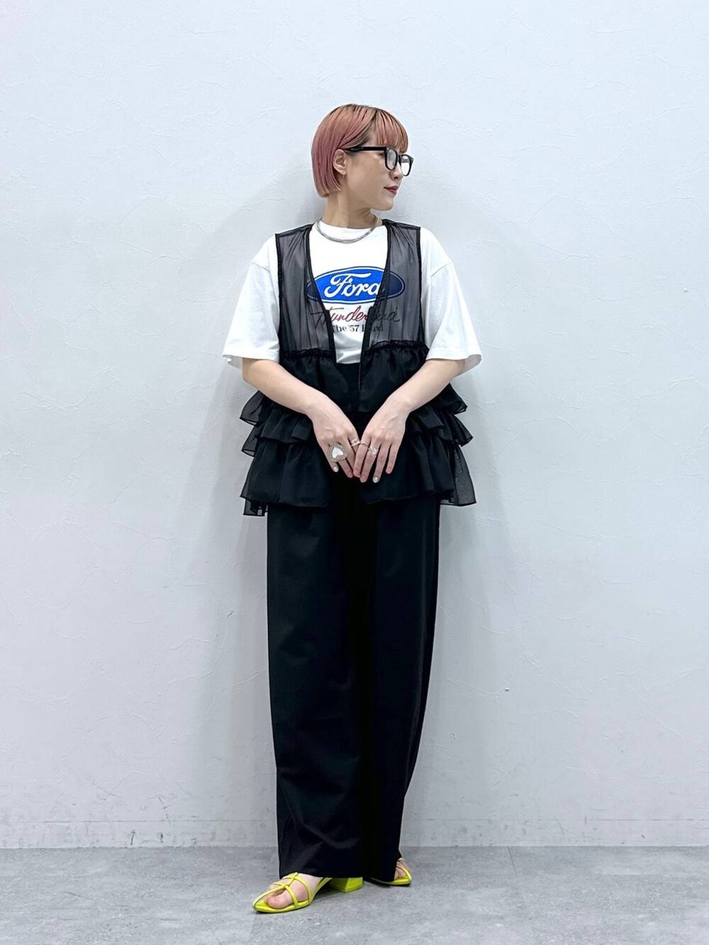 ブラック系のスラックス、ブラック系のベスト、ホワイト系のTシャツ/カットソーを着用したレディースの春コーディネートの3枚目の写真