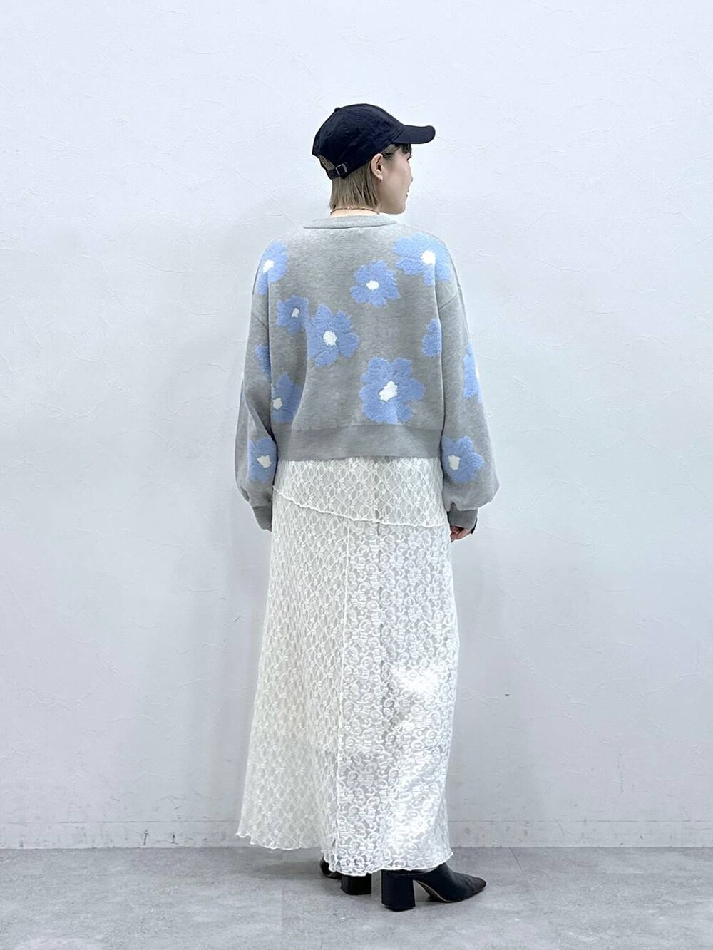 グレー系のニット/セーター、ホワイト系のスカートを着用したレディースの冬コーディネートの7枚目の写真