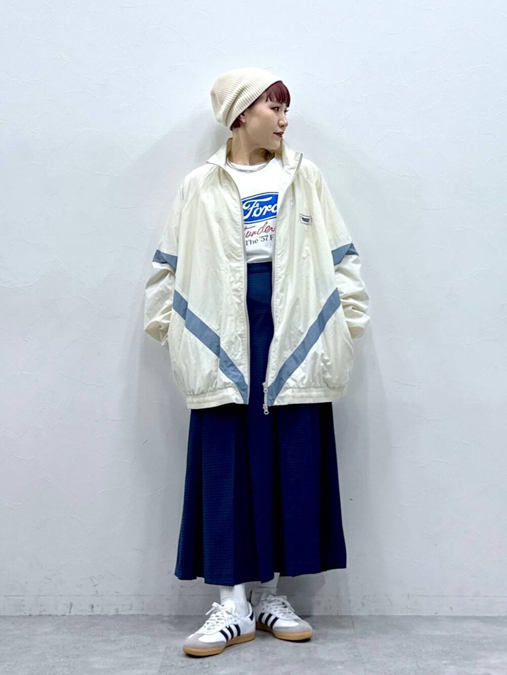 ホワイト系のブルゾン、ブルー系のスカートを着用したレディースの春コーディネートの3枚目の写真