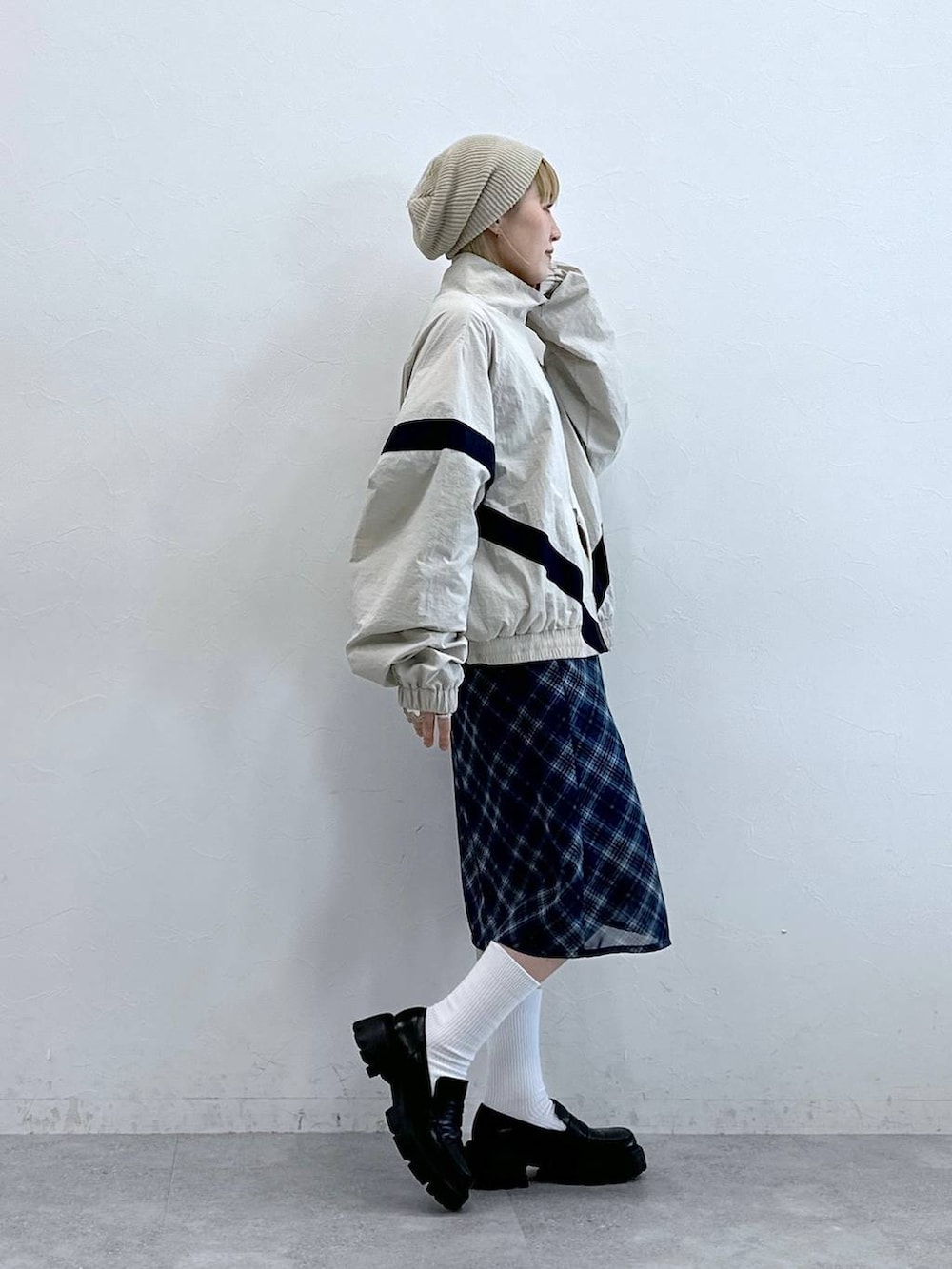 ブラック系のローファー、ブルー系のスカート、ホワイト系のブルゾンを着用したレディースの夏コーディネートの6枚目の写真