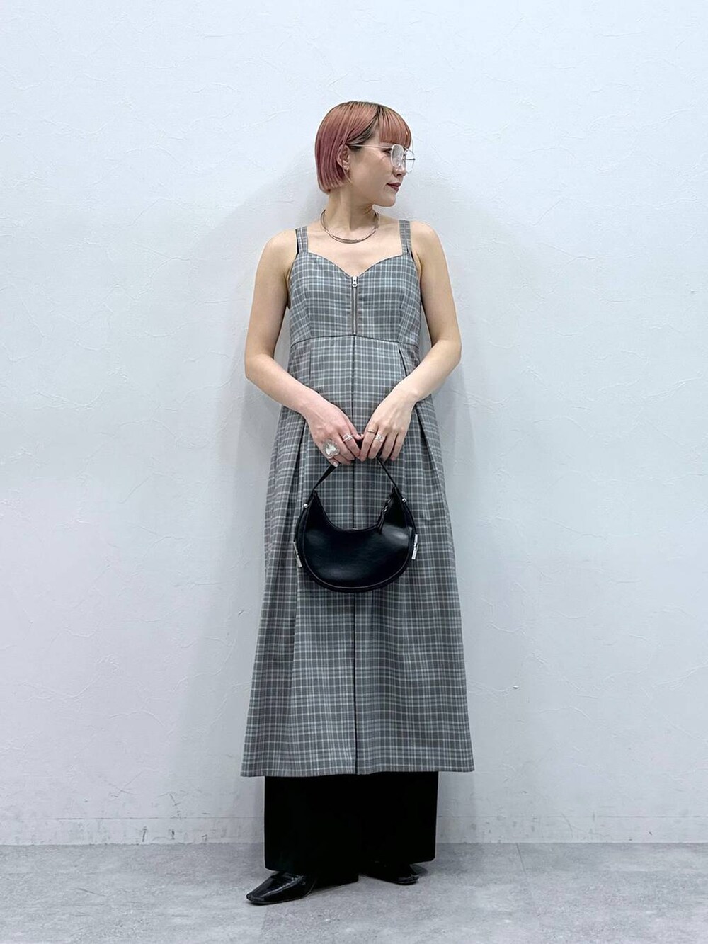 グレー系のワンピース、ブラック系のスラックスを着用したレディースの春コーディネートの2枚目の写真