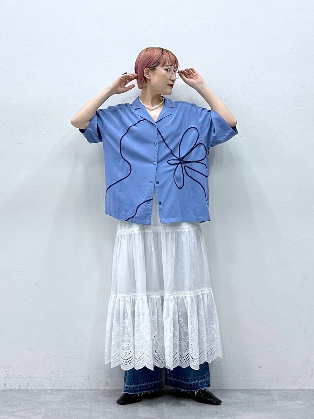 ブルー系のデニムパンツ、ブルー系のシャツ/ブラウス、ホワイト系のスカートを着用したレディースの春コーディネートの2枚目の写真