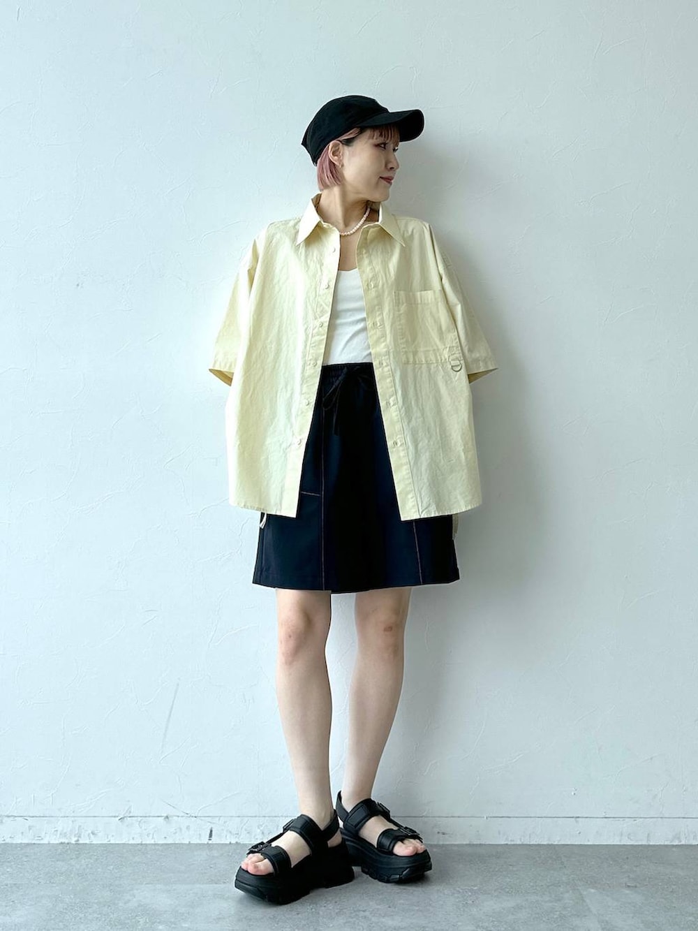 ブラック系のサンダル、ブルー系のスラックス、イエロー系のシャツ/ブラウスを着用したレディースの春コーディネートの2枚目の写真