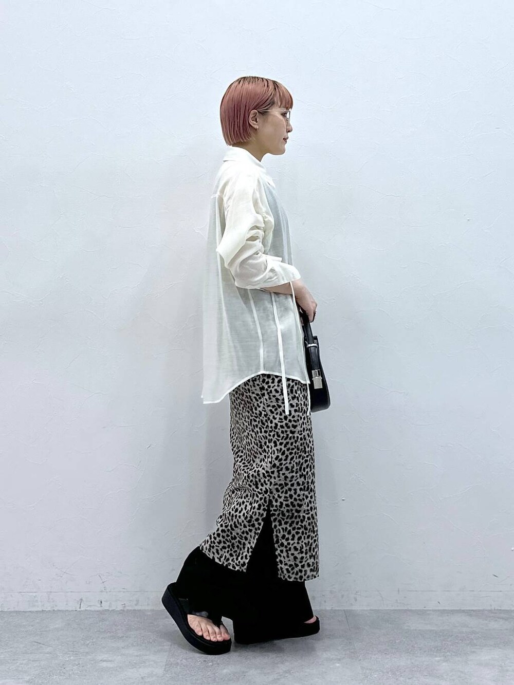 ブラック系のスラックス、ベージュ系のスカート、ホワイト系のシャツ/ブラウスを着用したレディースの春コーディネートの3枚目の写真