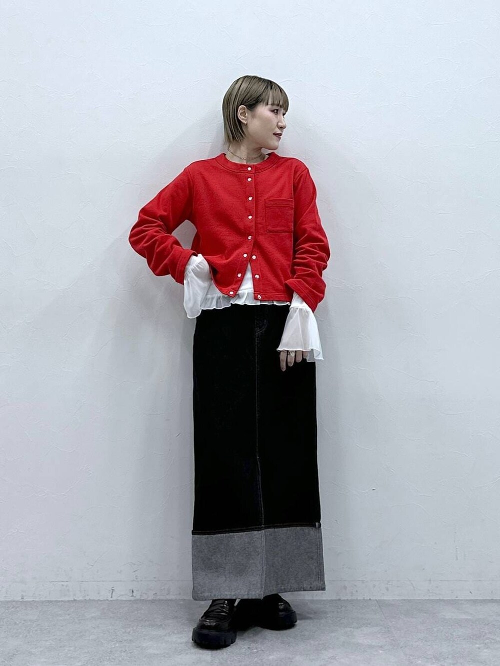 ブラック系のローファー、レッド系のカーディガン/ボレロ、ホワイト系のTシャツ/カットソーを着用したレディースの冬コーディネートの2枚目の写真