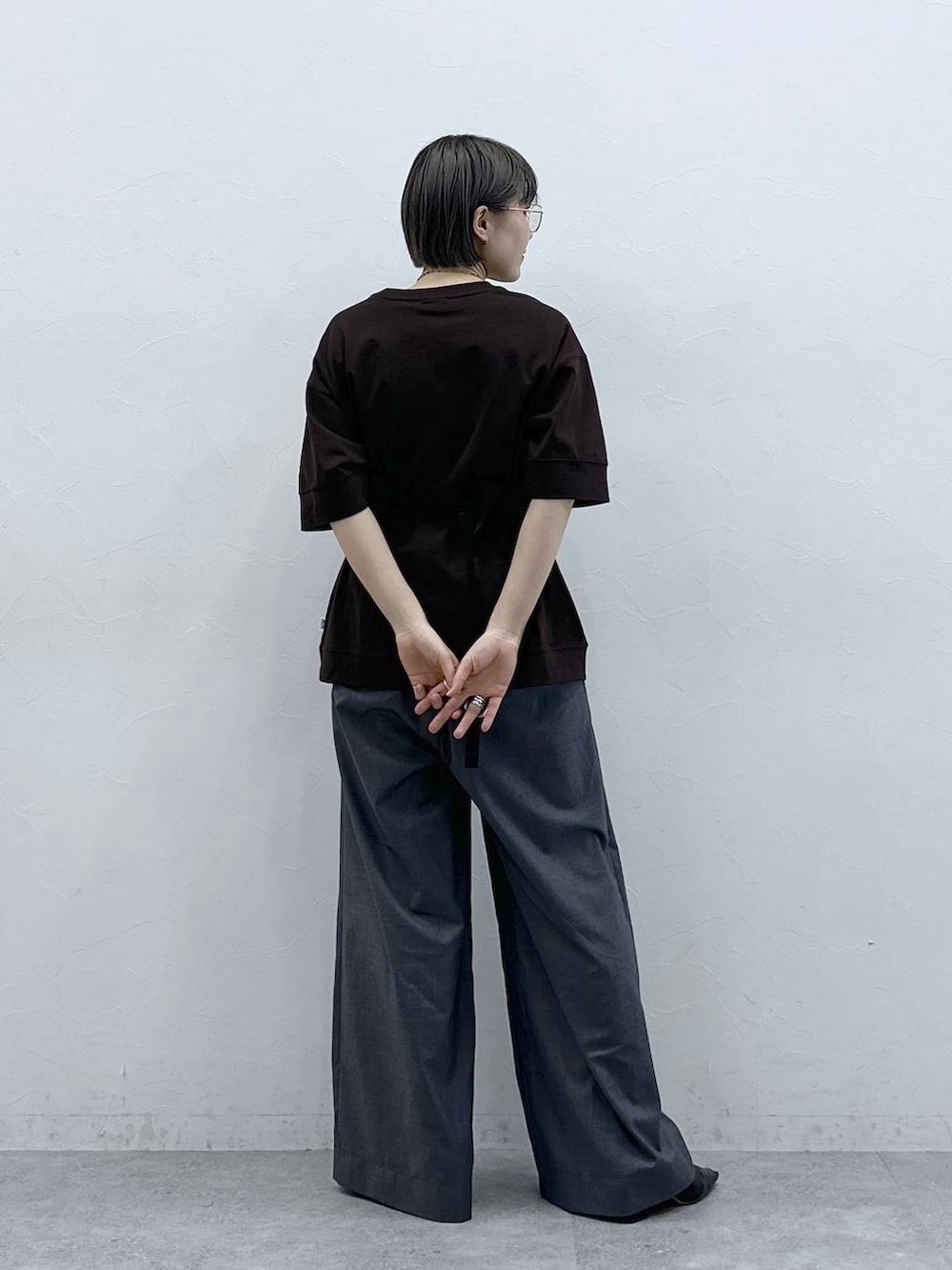 ブラウン系のTシャツ/カットソー、ブラック系のボディバッグ/ウエストポーチ、グレー系のスラックスを着用したレディースの春コーディネートの6枚目の写真