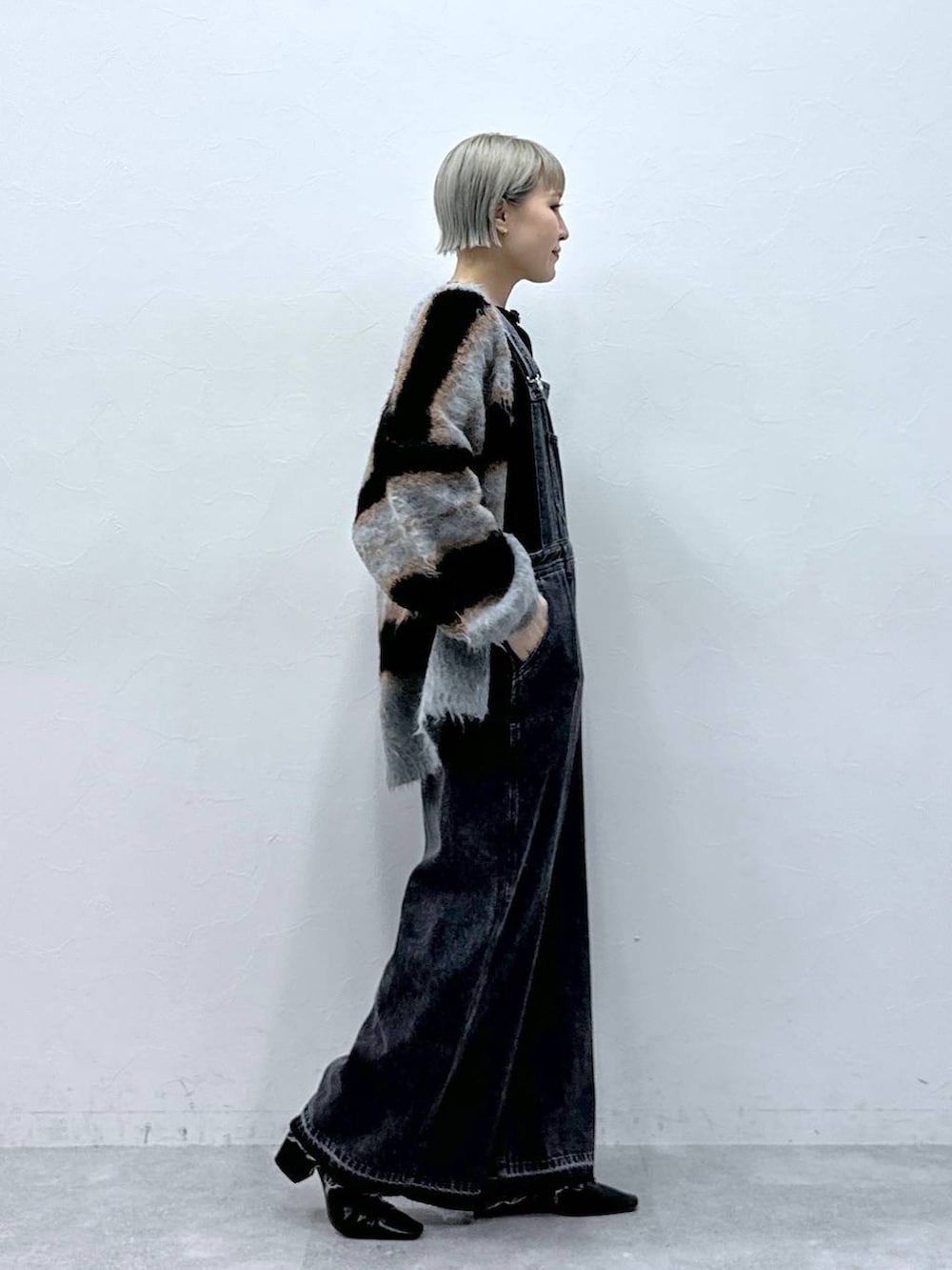 ブラック系のTシャツ/カットソー、ブラック系のカーディガン/ボレロ、ブラック系のサロペット/オーバーオールを着用したレディースの秋コーディネートの3枚目の写真