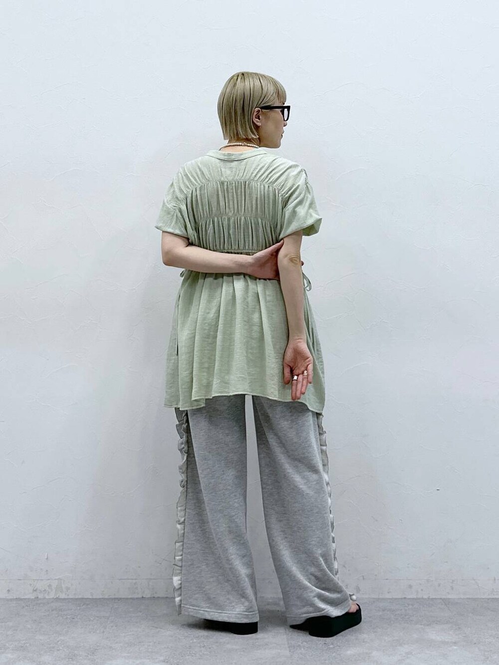 グレー系のスウェットパンツ、グリーン系のシャツ/ブラウス、ブラック系のサンダルを着用したレディースの夏コーディネートの7枚目の写真