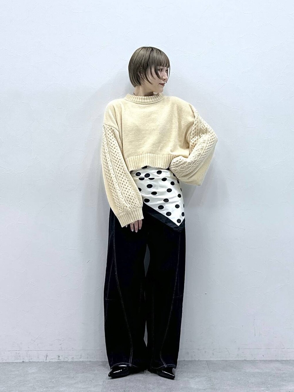 ホワイト系のニット/セーター、ブラック系のパンプス、ブラック系のデニムパンツを着用したレディースの冬コーディネートの2枚目の写真