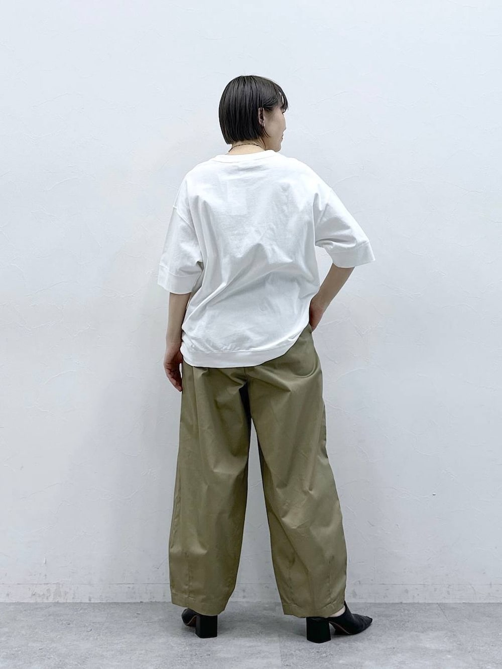ベージュ系のチノパンツ、ホワイト系のTシャツ/カットソーを着用したレディースの春コーディネートの6枚目の写真