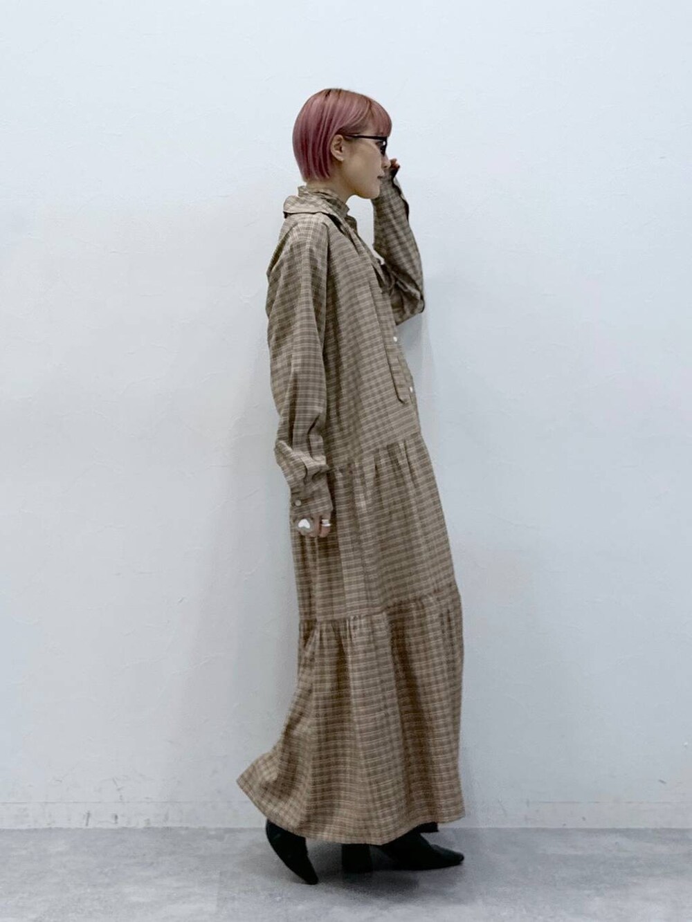 ブラック系のデニムパンツ、ベージュ系のワンピースを着用したレディースの冬コーディネートの5枚目の写真