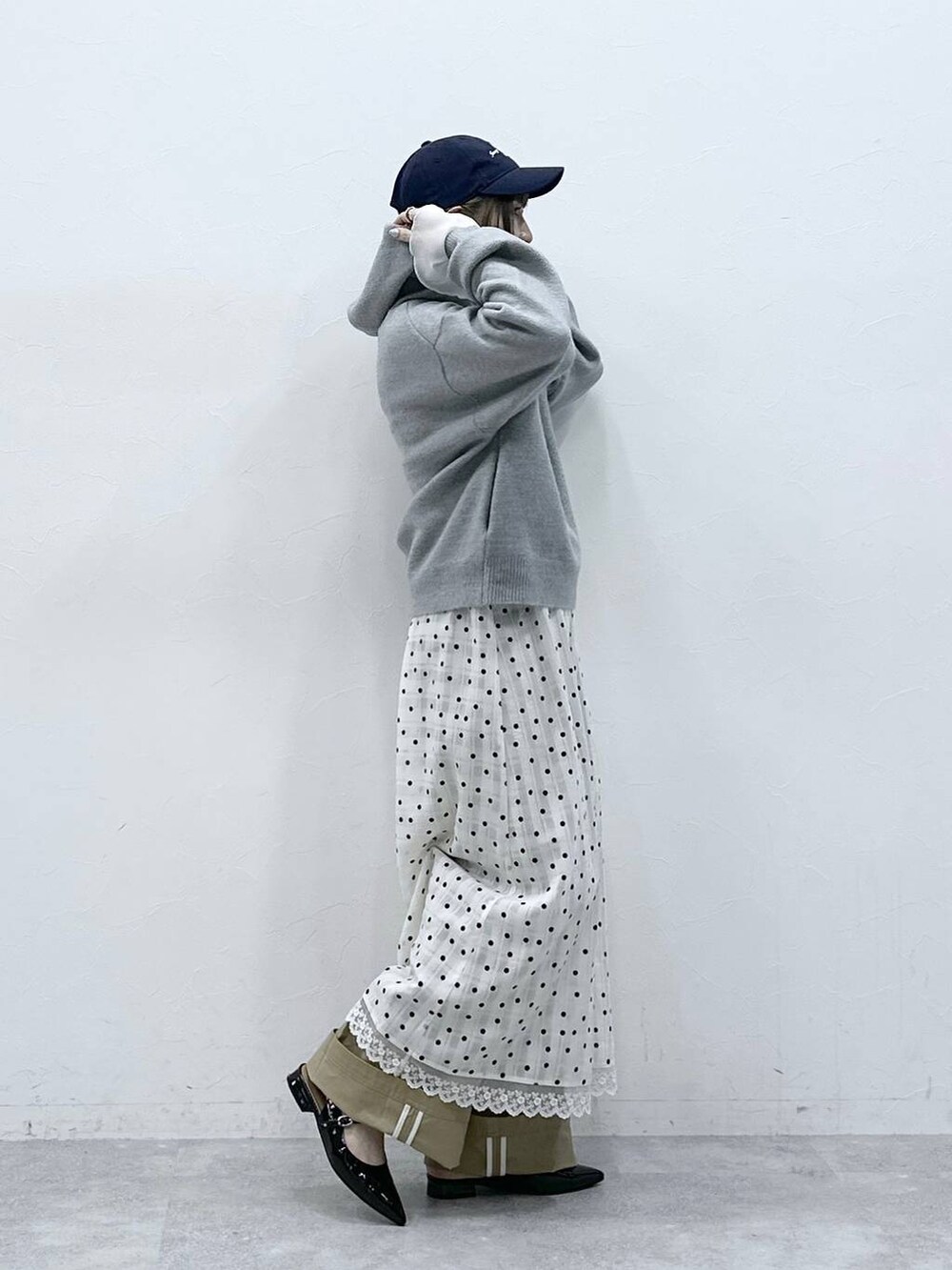 ブラック系のパンプス、グレー系のニット/セーター、ベージュ系のチノパンツを着用したレディースの冬コーディネートの4枚目の写真