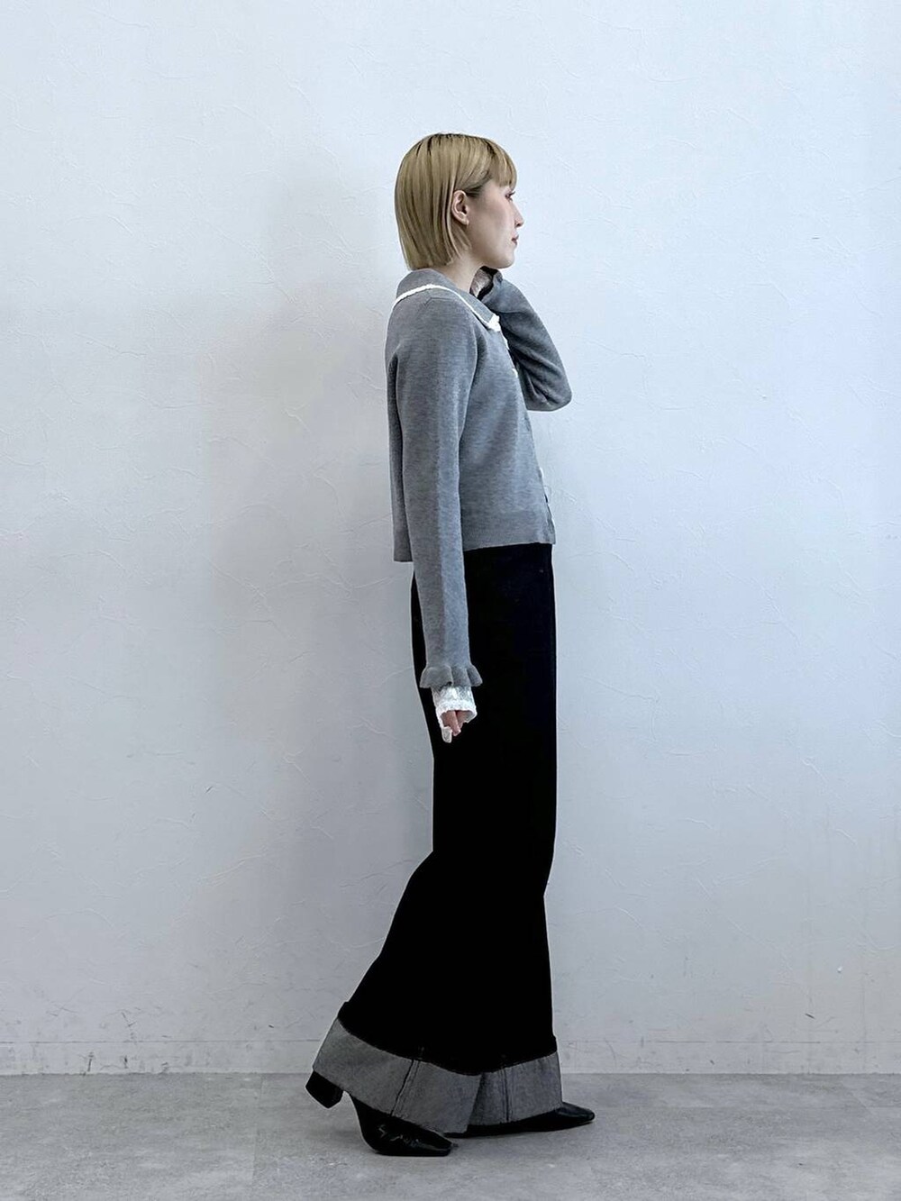 ブラック系のデニムパンツ、ホワイト系のTシャツ/カットソー、グレー系のニット/セーターを着用したレディースの夏コーディネートの4枚目の写真