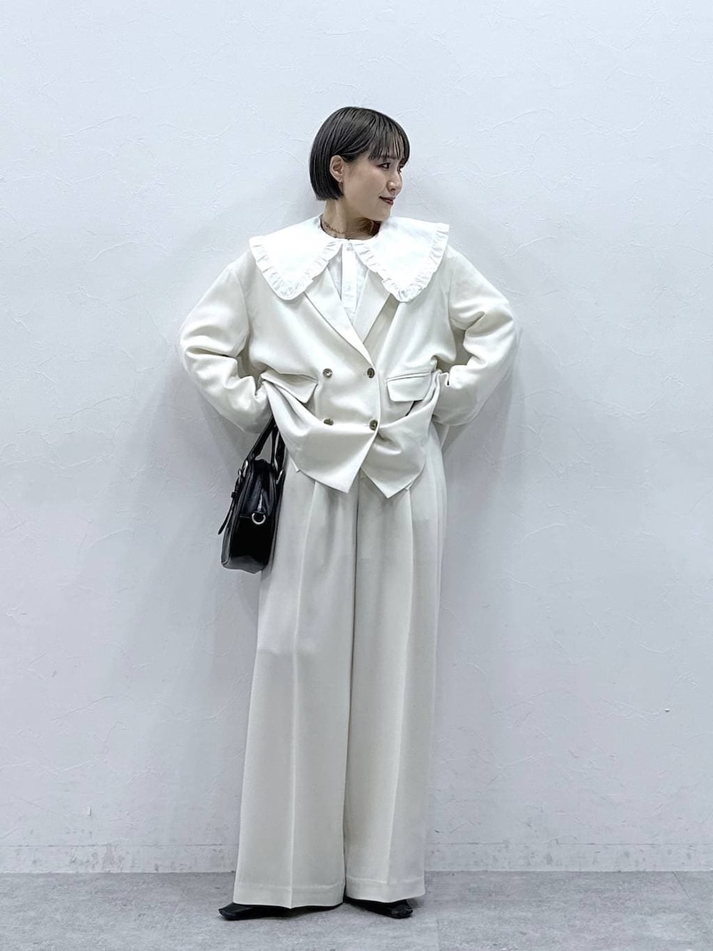 ホワイト系のシャツ/ブラウス、ブラック系のボストンバッグ、ホワイト系のテーラードジャケットを着用したレディースの春コーディネートの4枚目の写真