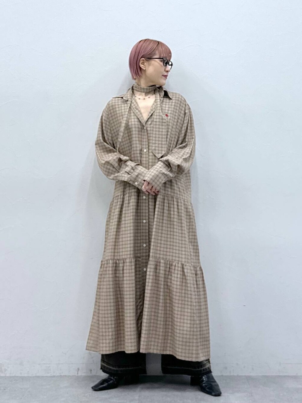 ブラック系のデニムパンツ、ベージュ系のワンピースを着用したレディースの冬コーディネートの7枚目の写真