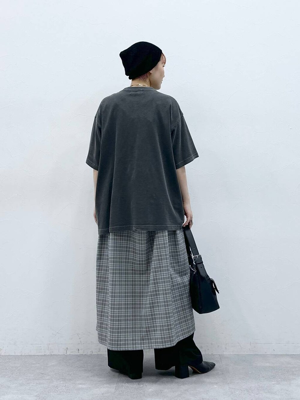 ブラック系のスラックス、グレー系のワンピース、ブラック系のTシャツ/カットソーを着用したレディースの春コーディネートの5枚目の写真