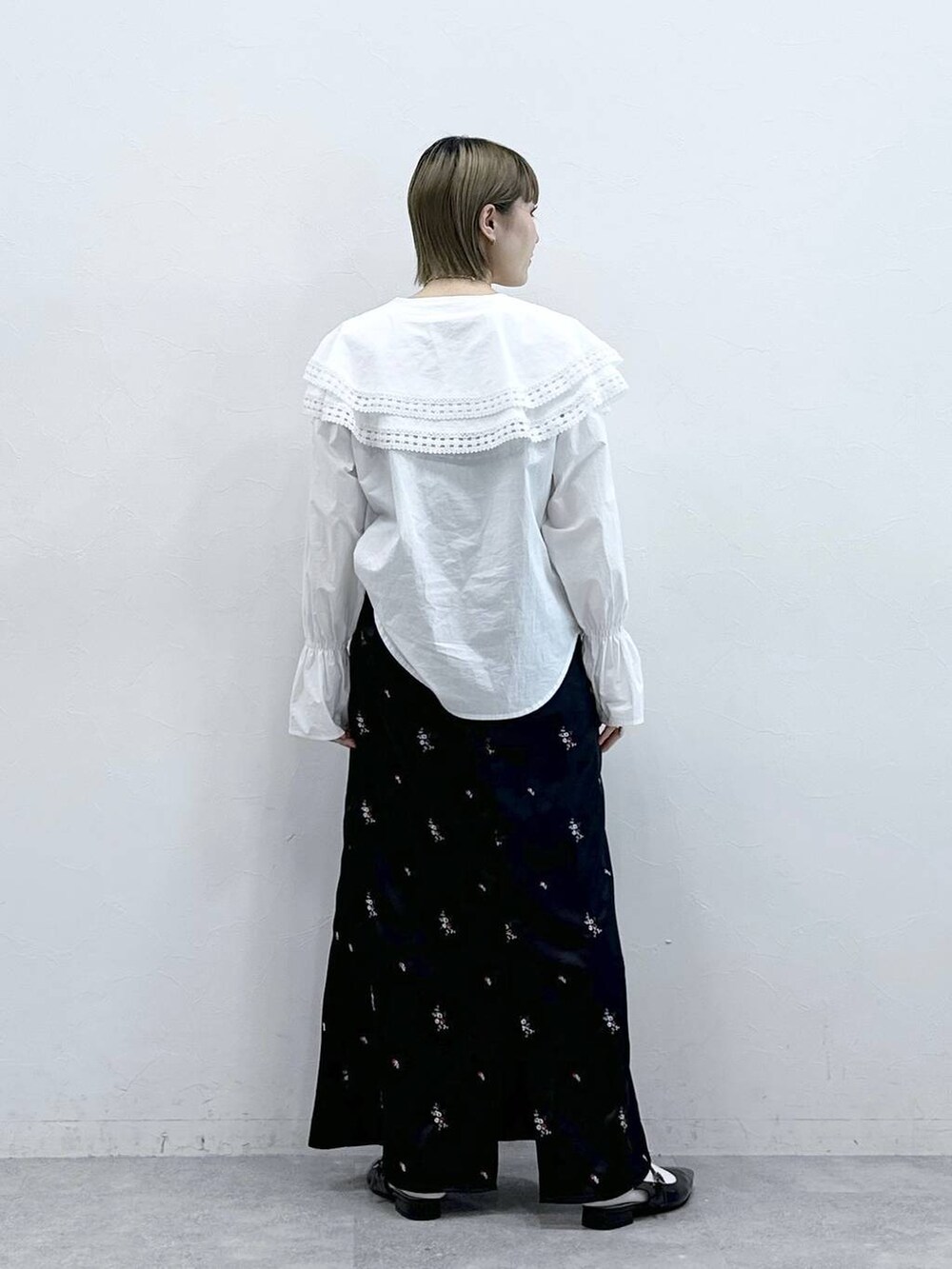 ホワイト系のシャツ/ブラウス、ブラック系のパンプス、ブラック系のスカートを着用したレディースの冬コーディネートの5枚目の写真