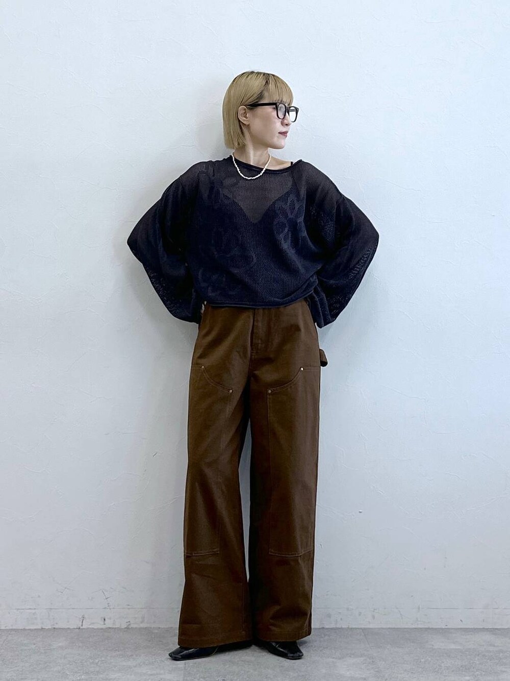 グレー系のニット/セーター、ブラウン系のチノパンツ、グレー系のメガネを着用したレディースの夏コーディネートの5枚目の写真