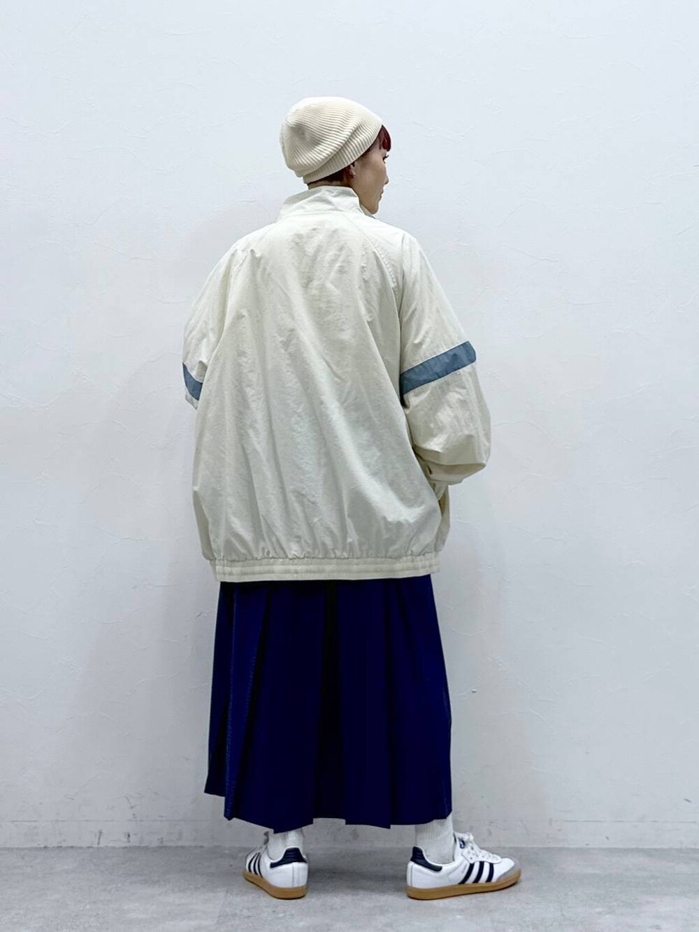 ホワイト系のブルゾン、ブルー系のスカートを着用したレディースの春コーディネートの5枚目の写真