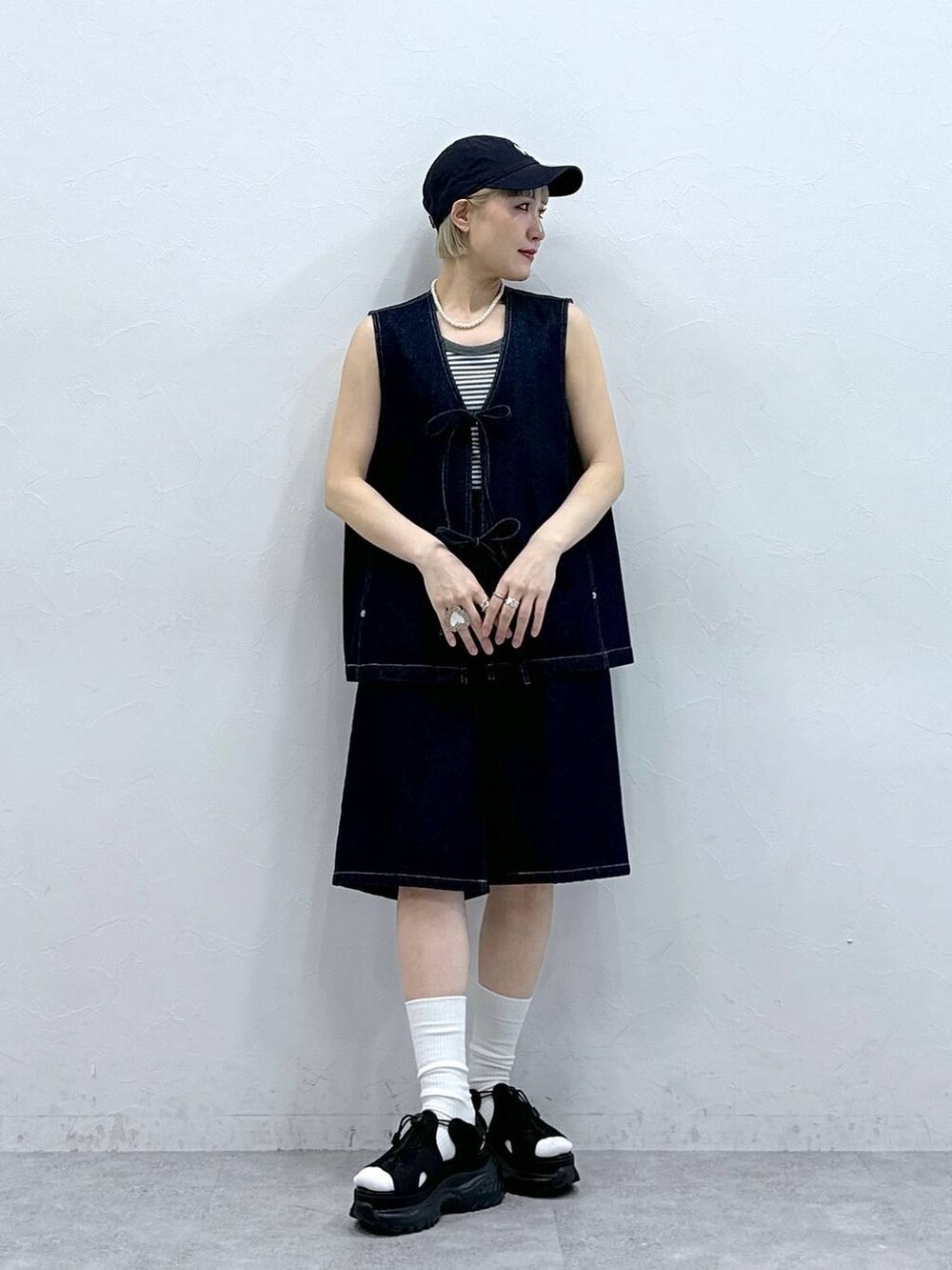 ブラック系のサンダル、グレー系のタンクトップ、ブルー系のベストを着用したレディースの夏コーディネートの4枚目の写真
