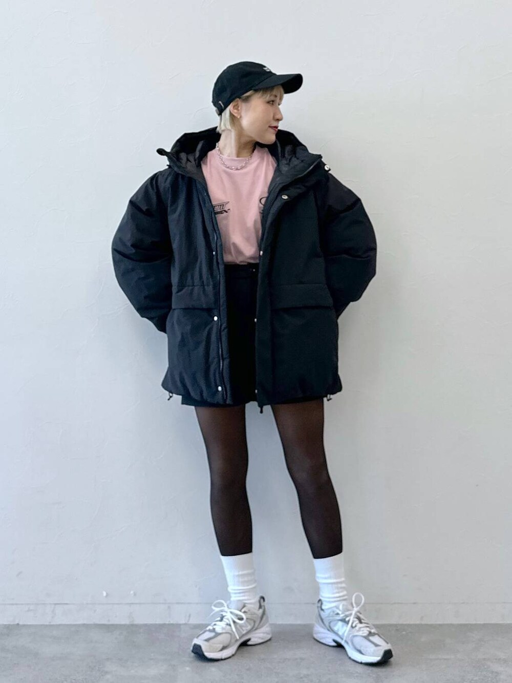 ブラック系のダウンジャケット/コート、ブラック系のその他パンツ、ピンク系のTシャツ/カットソーを着用したレディースの冬コーディネートの5枚目の写真