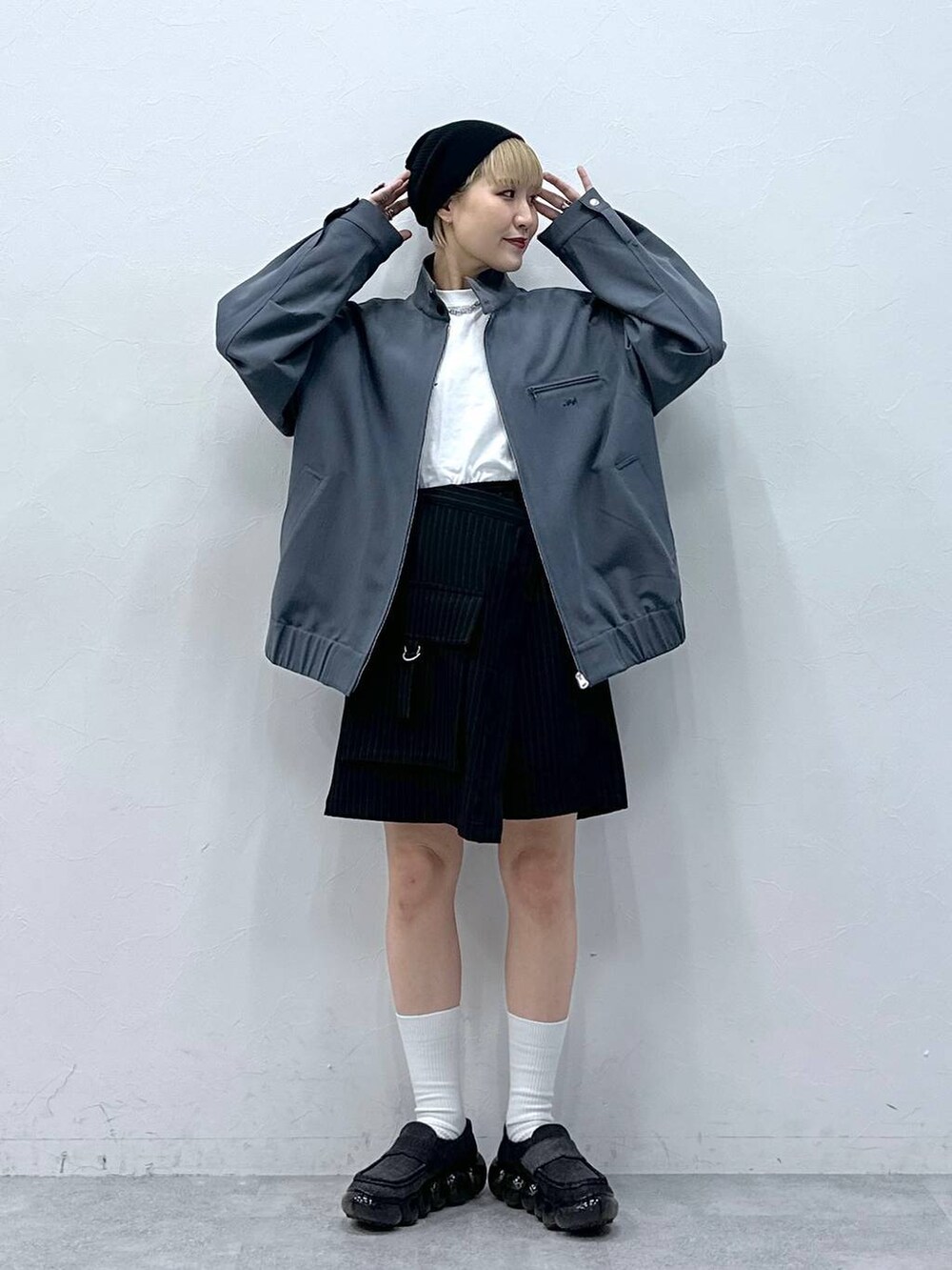 ブラック系のスカート、グレー系のブルゾンを着用したレディースの冬コーディネートの2枚目の写真