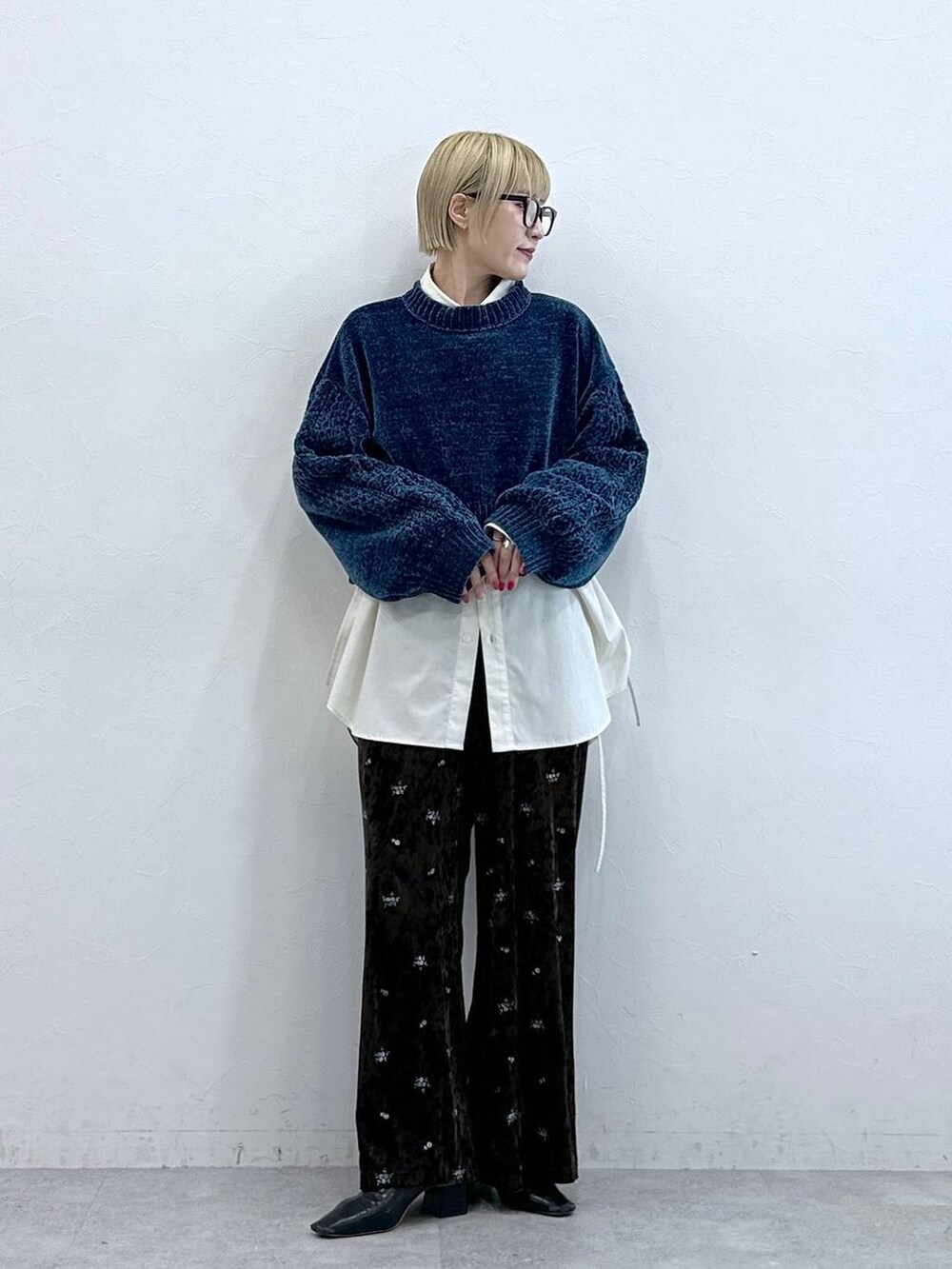 ブルー系のニット/セーター、ブラウン系のスウェットパンツ、ホワイト系のシャツ/ブラウスを着用したレディースの秋コーディネートの2枚目の写真