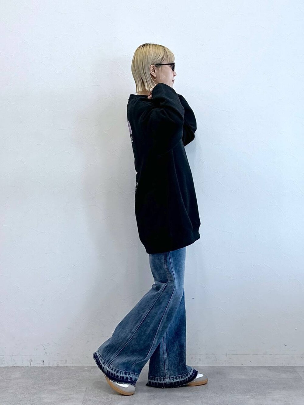 ブルー系のデニムパンツ、ブラック系のスウェット、ブラック系のサングラスを着用したレディースの秋コーディネートの5枚目の写真