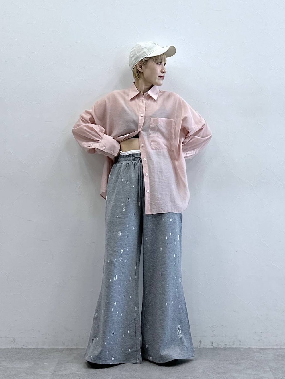 ピンク系のシャツ/ブラウス、グレー系のスウェットパンツ、ホワイト系のキャップを着用したレディースの春コーディネートの3枚目の写真